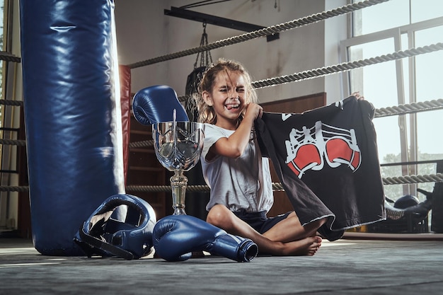 Das kleine Kind gewinnt seinen ersten Kampf im Boxclub und bekommt dafür Preise.