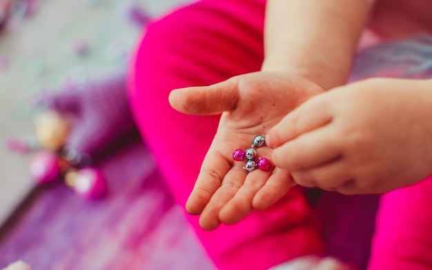 Das kleine Mädchen spielt mit Bällen und Steinen