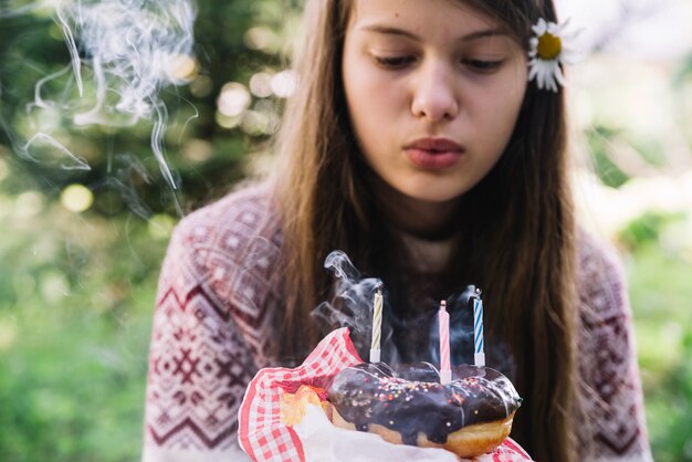 Das Mädchen, das durchbrennt, löschen Kerzen über dem Donut