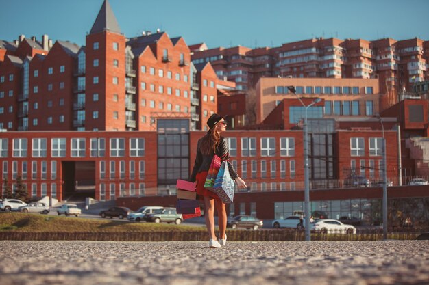 Kostenloses Foto das mädchen, das mit dem einkaufen auf stadtstraßen geht