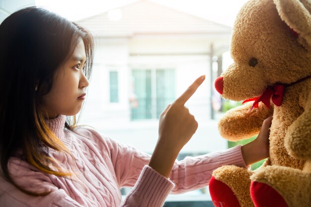 Das Mädchen, das Teddybären im Schlafzimmer ihres Hauses schimpft