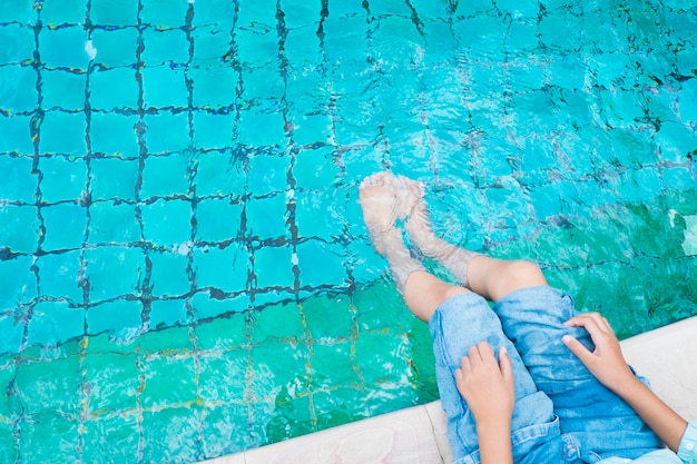 Das Mädchen entspannende Füße mit Wasser im Pool.