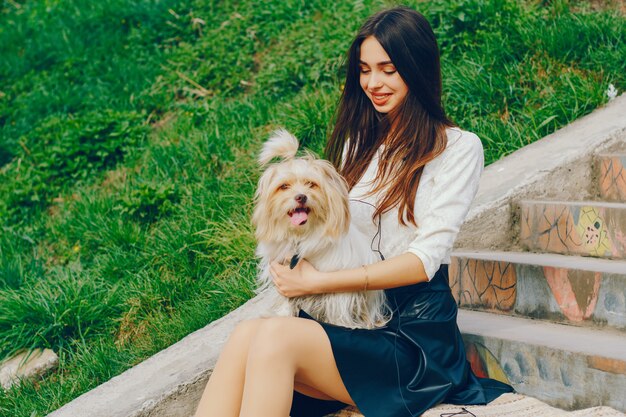 Das Mädchen geht mit ihrem Hund in den Park