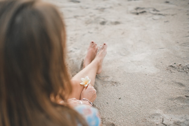 Das Mädchen sitzt am Strand