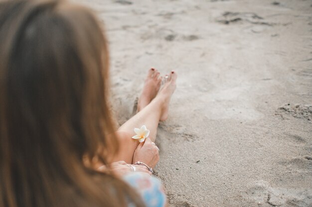 Das Mädchen sitzt am Strand