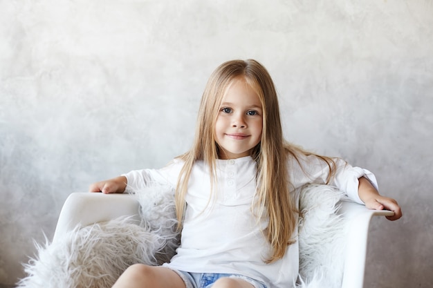 Das Mädchen sitzt im Wohnzimmer