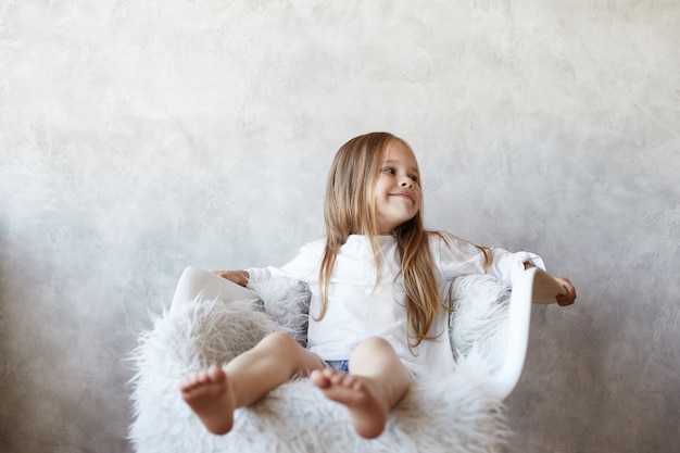 Das Mädchen sitzt im Wohnzimmer