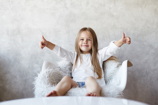 Das Mädchen sitzt im Wohnzimmer