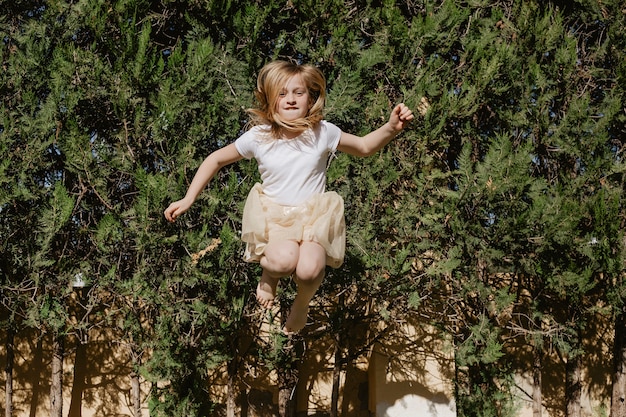 Das Mädchen springend nahe Bäumen