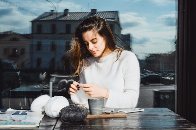 Das mädchen strickt in einem café