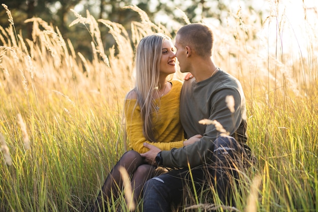 Kostenloses Foto das mädchen und der junge, die auf dem gras sittting sind