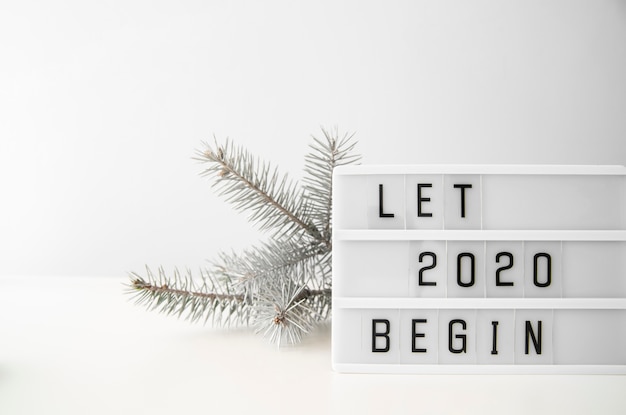 Das neue Jahr 2020 beginnt mit Ziffern und silbernen Weihnachtsbaumblättern