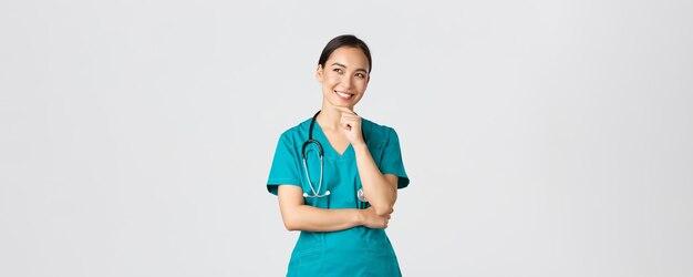 Das Pandemiekonzept von Covid-Gesundheitspersonal freute sich über eine attraktive asiatische Ärztin in Sc...