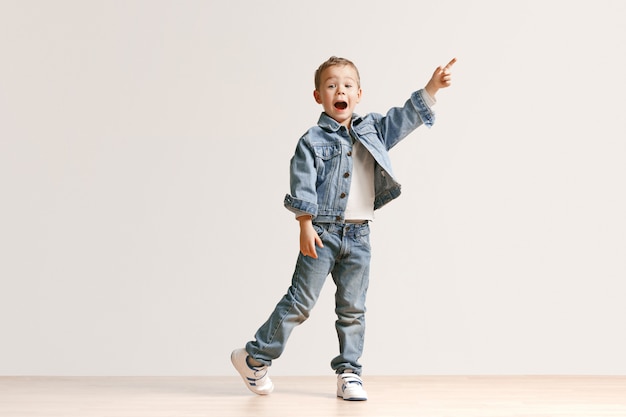 Das Porträt des niedlichen kleinen Jungen in der stilvollen Jeanskleidung
