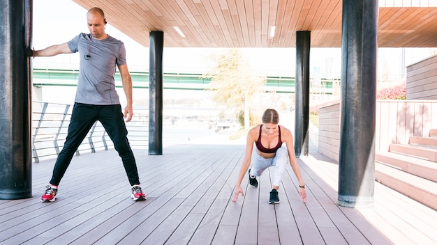 Das Porträt von den sportlichen Paaren, die das Ausdehnen tun, trainiert im Park vor der Ausbildung