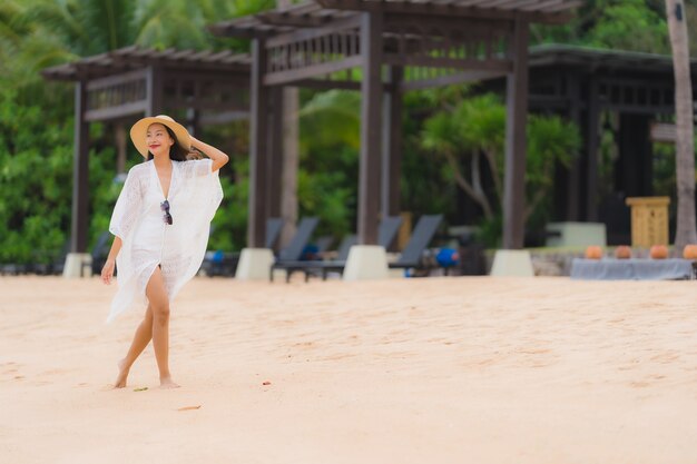 Das schöne junge asiatische glückliche Frauenlächeln des Porträts entspannen sich auf dem Strandseeozean