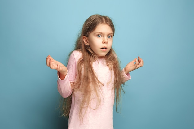 Das überraschte Teenager-Mädchen in einem blauen Studio