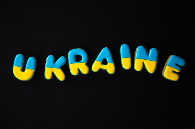 Das Wort Ukraine auf schwarzem Hintergrund mit handgemachtem Lebkuchen