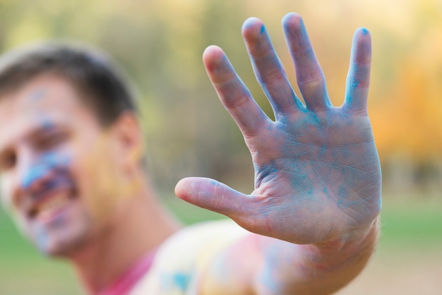 Defocused Mann, der blaue Hand am Festival zeigt