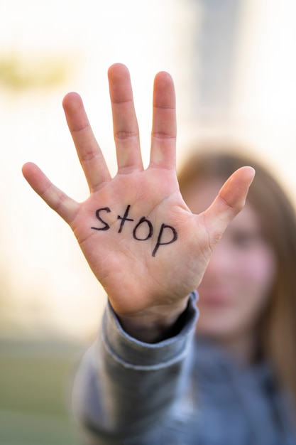 Defokussierte Person, die mit dem Schreiben auf der Hand für den Weltumwelttag im Freien protestiert