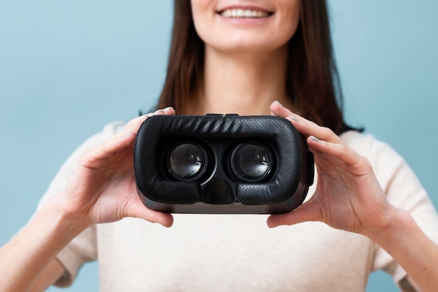 Defokussierte Smiley-Frau, die Virtual-Reality-Headset hält