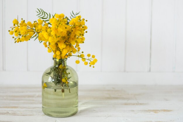 Dekorative Vase mit schönen Blumen auf hölzernen Oberfläche