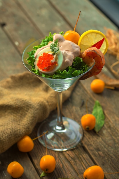 Dekorative Vorspeise der Vorderansicht in einem Glas mit Garnelensauce eine Scheibe Zitronen-Kaviar