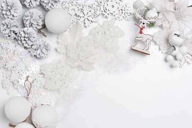 Dekorative Weihnachtszusammensetzung von Spielzeugen auf einem weißen Tischhintergrund. Draufsicht. Flache Lage