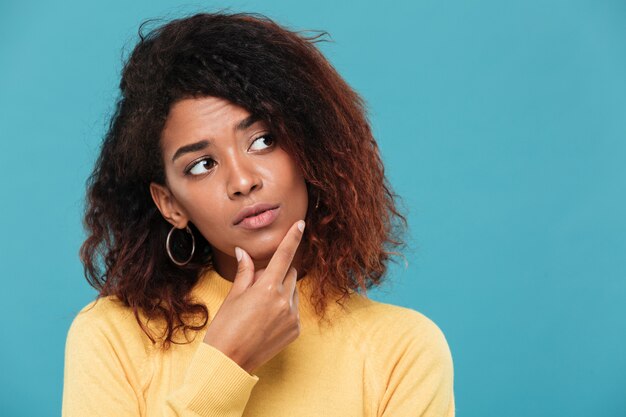 Denkende junge afrikanische Dame gekleidet in warmen Pullover