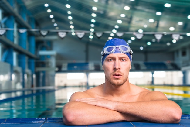 Denkender männlicher Schwimmer, der Fotografen betrachtet