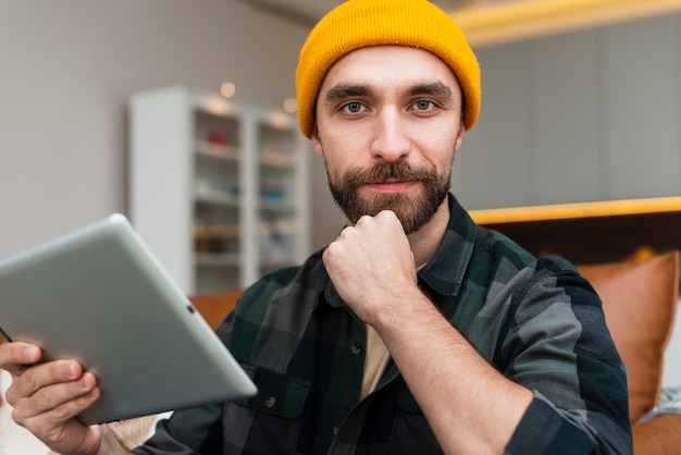 Kostenloses Foto denkender mann, der eine tablette hält