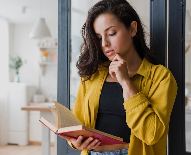 Denkendes Mädchen des mittleren Schusses mit Buch