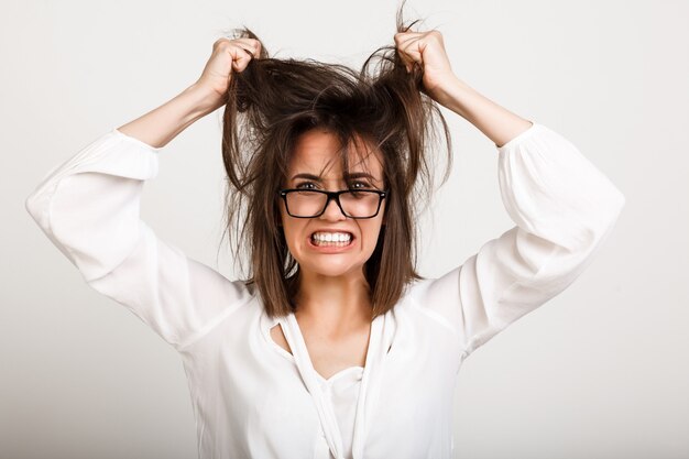 Depressive Frau, die emotionalen Burnout hat und Haare zieht