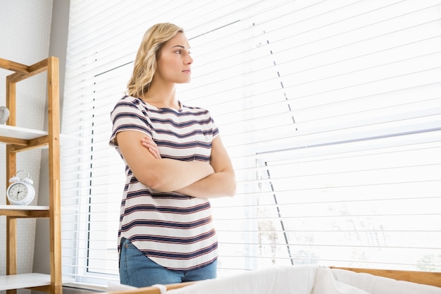 Depressive Frau im tiefen Gedanken auf Fensterbank