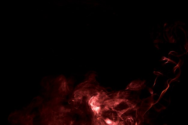 Der abstrakte brennende helle Rauch auf einem schwarzen Hintergrund