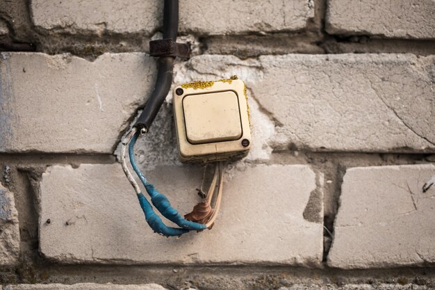 Der alte Schalter an der Mauer verdrehte das blaue Klebeband.