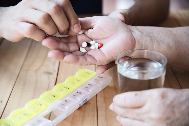 Kostenloses Foto der arzt hilft dem patienten, die medizintablette in der pillendose richtig zu essen