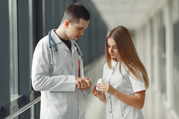 Der Arzt teilt Tabletten in Händen an einen anderen Arzt