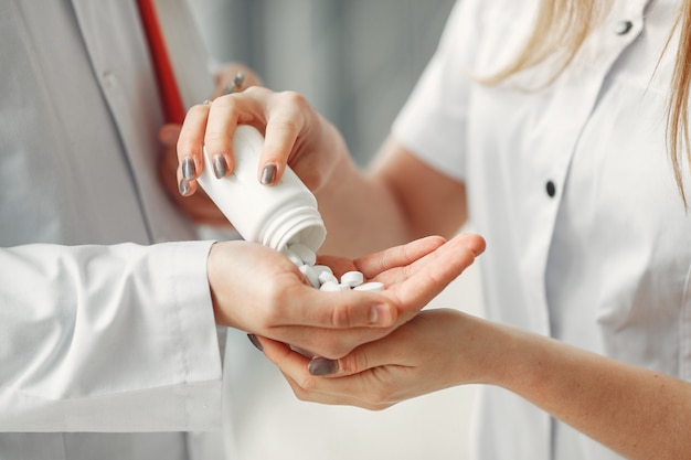 Der Arzt teilt Tabletten in Händen an einen anderen Arzt