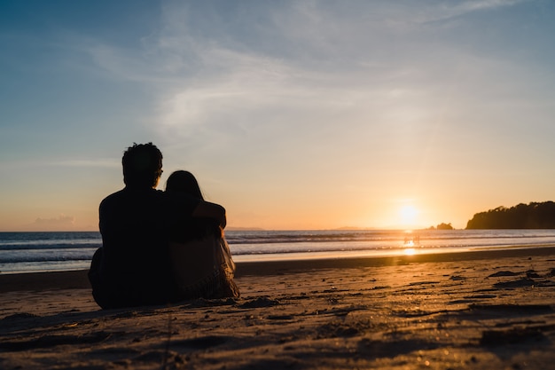 Der aufpassende Sonnenuntergang der jungen asiatischen Paare nahe dem Strand, das glückliche süße Paar entspannen sich genießen Liebe und romantischen Moment