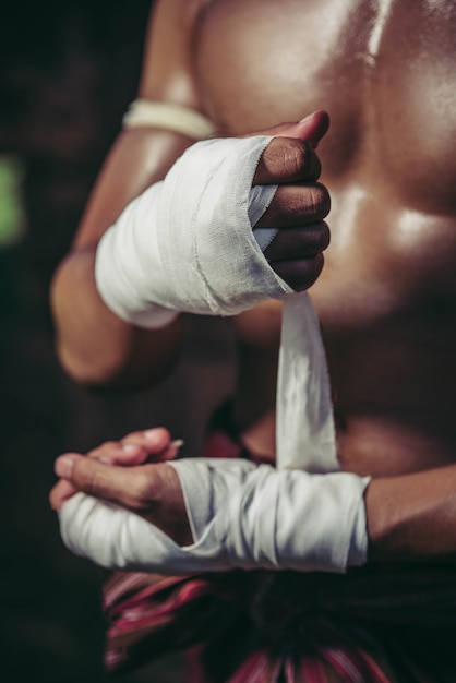 Der Boxer saß auf dem Stein, band das Band um seine Hand und bereitete sich auf den Kampf vor.