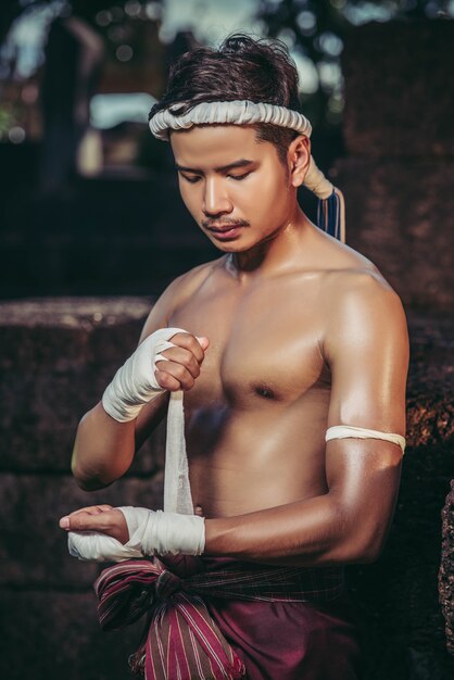 Der Boxer saß auf dem Stein, band das Band um seine Hand und bereitete sich auf den Kampf vor.