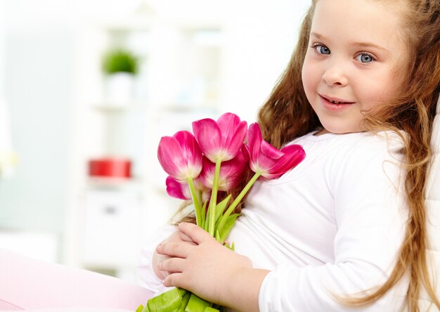 Der entzückende kleine Mädchen mit Blumen