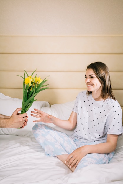 Kostenloses Foto der frau im bett blumen schenken