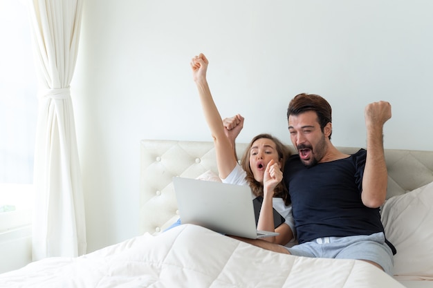 Der hübsche Ehemann und die schöne Ehefrau fühlen sich großartig, wenn der Fußball, den sie anfeuern, der Sieger im Schlafzimmer ist