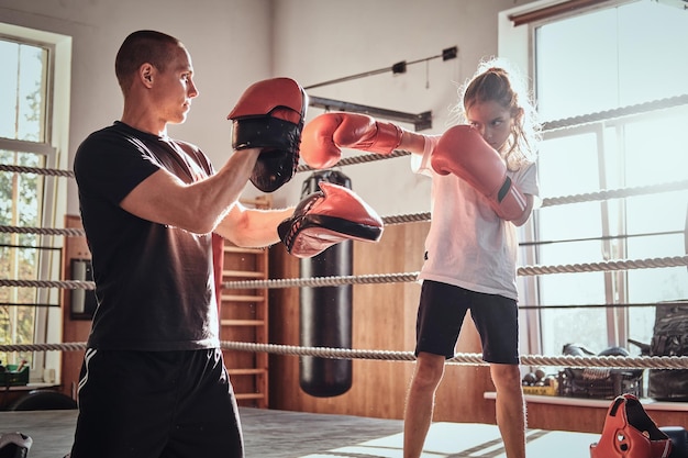 Kostenloses Foto der junge boxertrainer trainiert neue boxerinnen für spezielle wettkämpfe.
