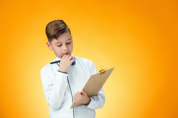 Der Junge mit Stift und Tablette für Notizen