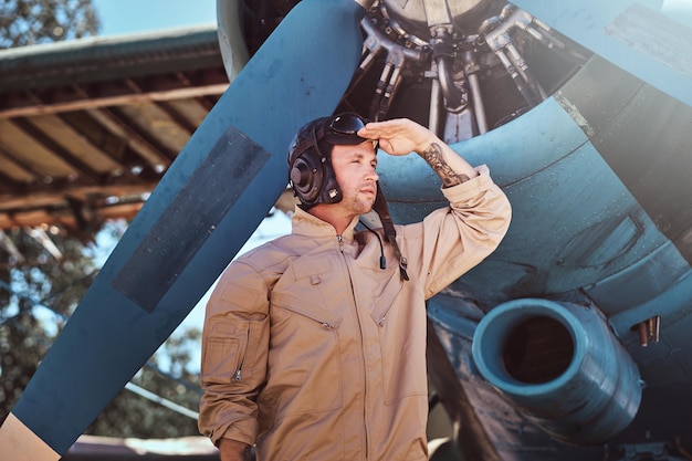 Der junge Pilot steht neben seinem Jet.