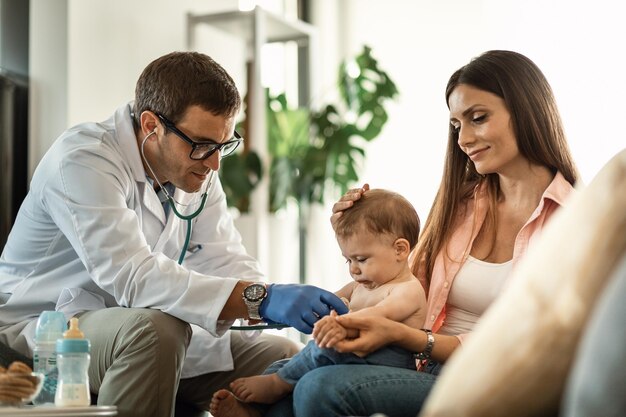 Der kleine Junge wird von einem Arzt untersucht, während er bei der Mutter beim Kinderarzt ist