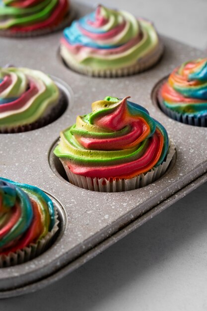 Der köstliche Regenbogen-Cupcake ist ein Stillleben.